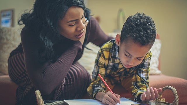 Preschool boy with his mother doing homework