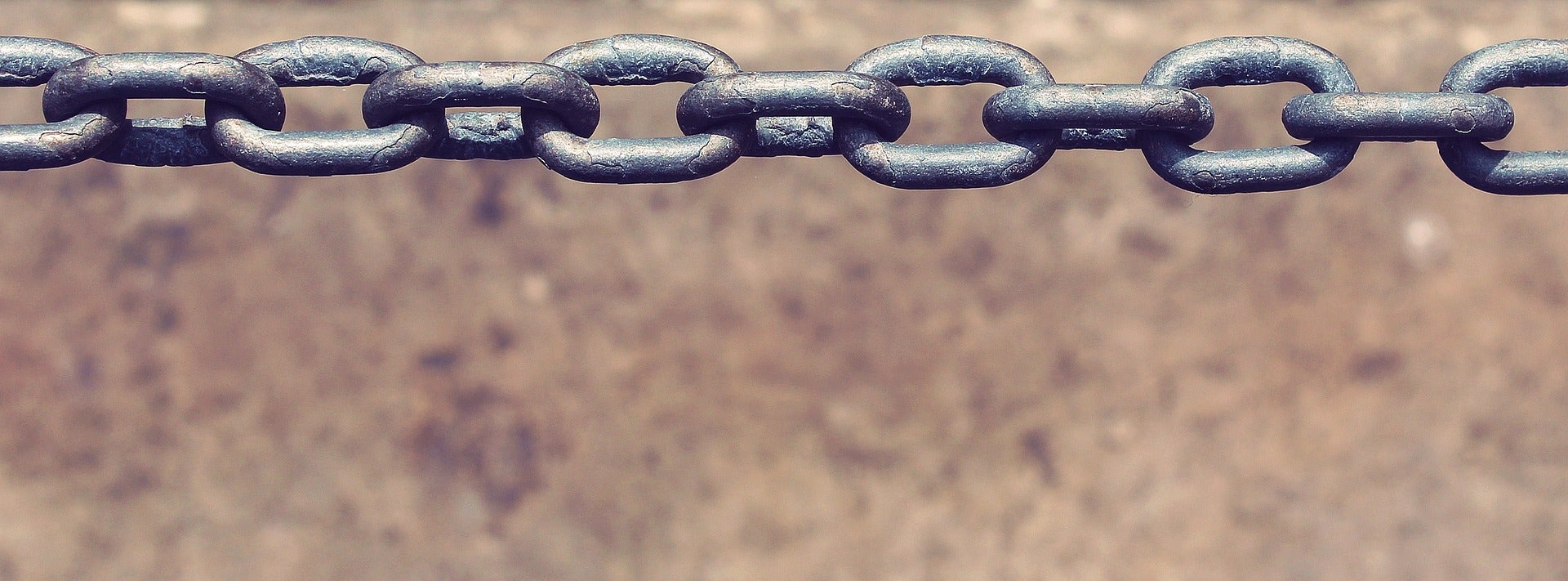 a metal chain with a neutral textured tan background.