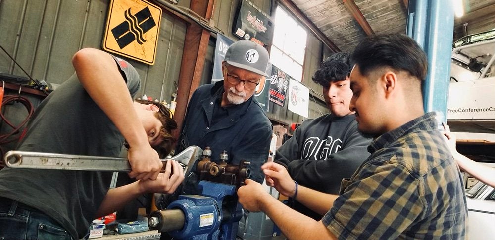 An intergenerational group works on an engine in Long Beach, CA. Photo credit: DSF Werks