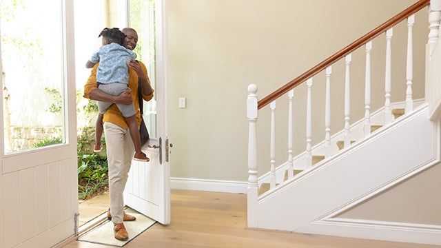 Man carries child into home